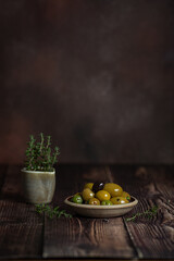 Bowl with different olives on dark wooden background 