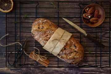 whole loaf of bread with cranberries and nuts on dark background 