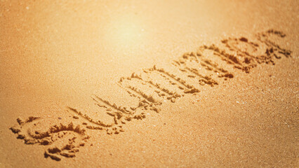 The word summer is written on the yellow sand of the beach. Resort and vacation concept. Summer on the seaside. Selective focus.