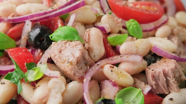 White bean tuna salad with olive, red onion, tomatoes. Healthy food. Rotating video