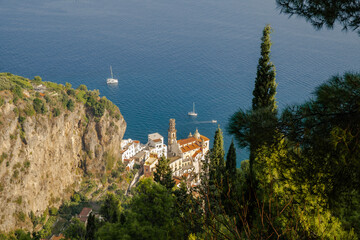 Small Italian village Atrani on the shore of the Mediterranean Sea lost between mountains and hight trees shot from a high angle. Aerial view