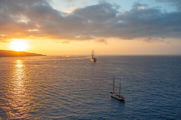 Coastline On Sunset With Two Ships Sailing Towards Horizon