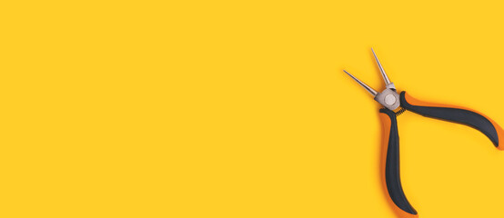 Banner with round-nose pliers laid on a yellow background. Place for text.
