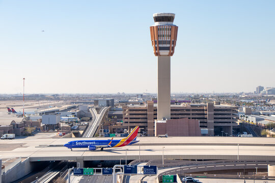 Aerial view of a Southwest Airlines Boeing 737 on bridge taxiway at Phoenix Sky Harbor International Airport with the PHX Air Traffic Control Tower in the background - Phoenix, Arizona, USA	