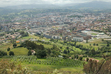 Fototapeta na wymiar A vast landscape of the city of Oviedo in Spain. This small European city has a lot of mountains and trees surrounding the busy historic center. 