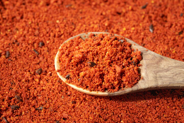 Sea buckthorn powder with seeds on a wooden spoon