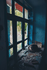Old abandoned room and old hat and photo on window. Old ruined house. interior of an abandoned...