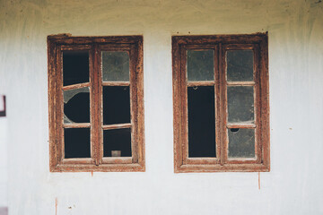an abandoned broken windows. Old destroyed houses. Broken glass in the window. War, destruction, restructuring. abandoned, useless houses. Consequences of social and economy problems. Empty house
