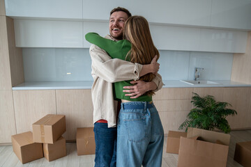 Happy married couple hugging of joy and happiness in own apartment. Joyful wife and husband...