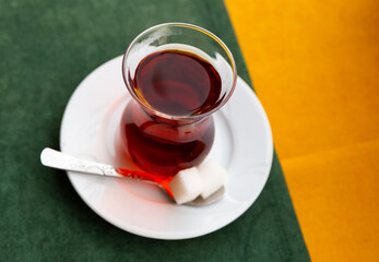 Close-up Of fresh hot Turkish tea with two sugar cubes served on table