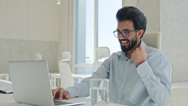 Happy Arabian man Indian muslim businessman employer professional manager office worker work laptop computer amazed shocked win business achievement online victory celebrate success wonder euphoria