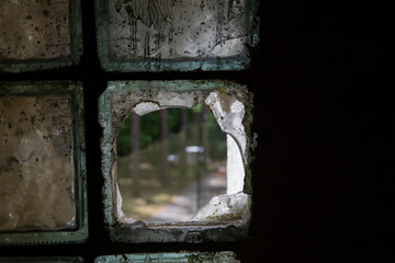 The window is old and dirty, broken from colored glass.