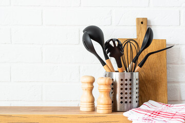 Kitchen utensils. Cooking tools with wooden cutting boards, oil and shaker at white modern kitchen...