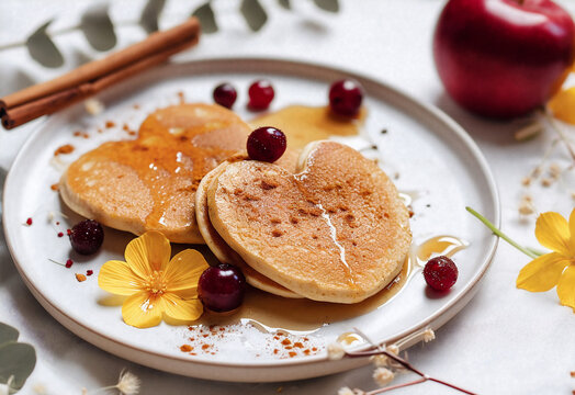 Heart shaped pancake for a romantic morning breakfast on Valentine's Day surrounded with fruits, berries and syrup or honey. Generative AI 