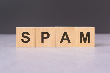 Wooden cubes align to spell SPAM, embodying the issue of unwanted communication