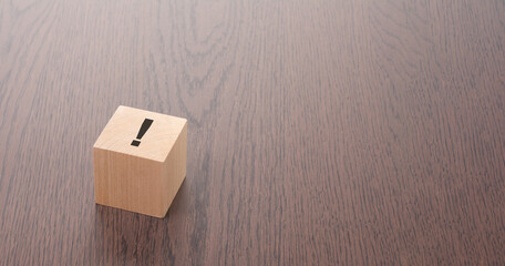 exclamation point on the top of a wooden cube. concept: visualizing emphasis, uniqueness, or...