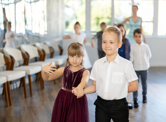 Group of cheerful emotional tweens, girls ad boys in formal wear dancing slow romantic partner...