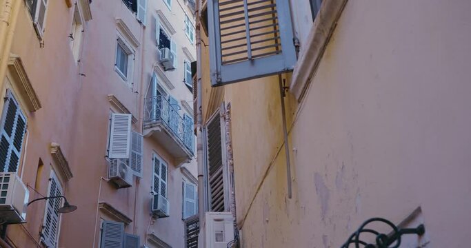 Narrow street and traditional architecture and window blinds of the seedy town of Corfu island in Greece