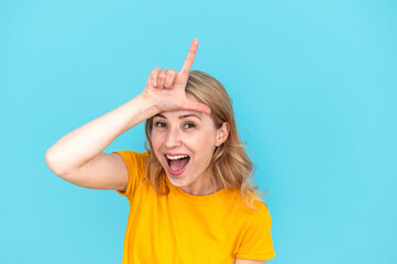 Woman showing loser gesture by fingers on forehead