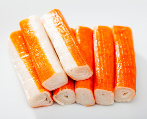 Many crab sticks on white surface