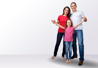 young joyful parents with children posing on background