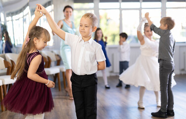 Children dance in pairs at a festive matinee