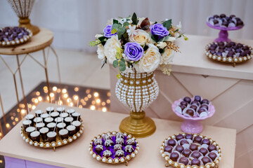 a table decorated with wedding sweets LED lights in the background