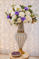 a table decorated with wedding sweets LED lights in the background, with a wedding cake in the center