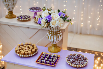 a table decorated with wedding sweets LED lights in the background