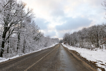 Obraz na płótnie Canvas Snowy mountain roads. Road landscape in winter. Winter vacation concept. Road Leading Into Winter Mountain Landscape.