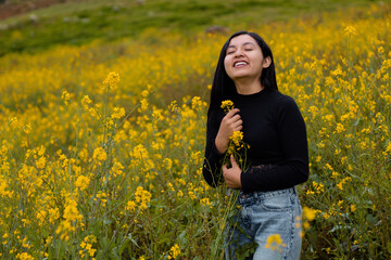 Una chica turista sensual alegre,camiseta negra  y celular en el paraíso floral, Encanto...