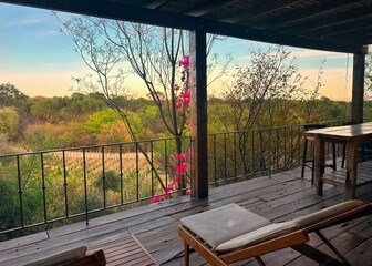 View of a desert landscape from a second story deck lined with red bougainvillea