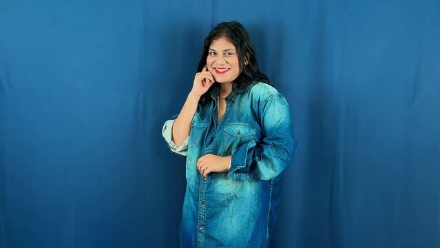 Smiling woman nodding neck in denim shirt posing against a blue background asian sexy hot girl