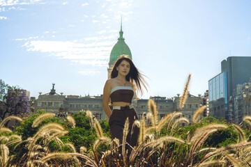 Young Latin woman tourist looks at the camera on a sunny day in buenos aires, with the argentine...