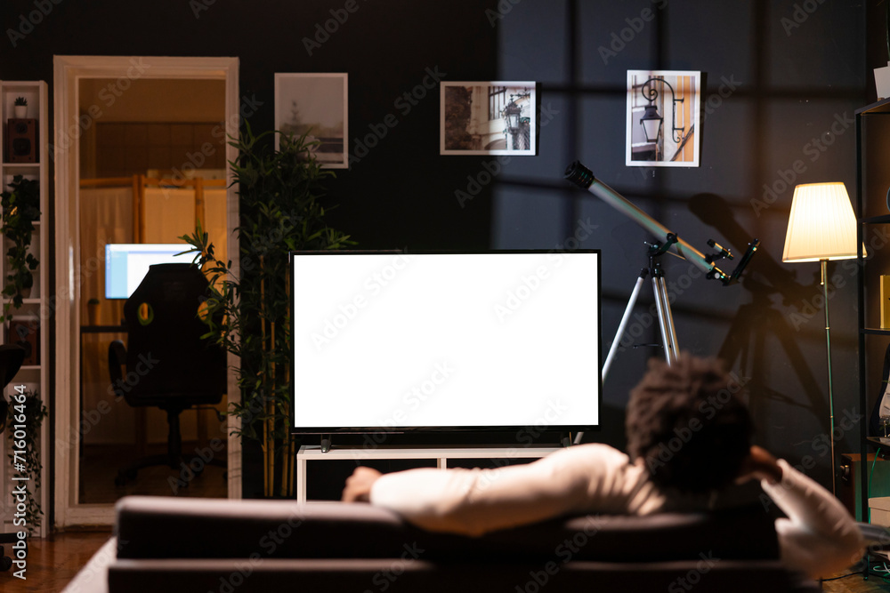 Poster homeowner bored at home, using isolated screen smart tv to binge series on subscription based stream