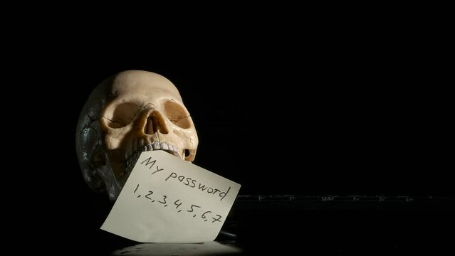 Easy hacking password on black. A view of easy hacking password in the skull mouth on the keyboard against black background. A concept of problems with web sites and internet security.
