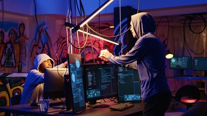 Hacker in hidden bunker uploading script on SSD that can launch DDoS attacks on any website,...