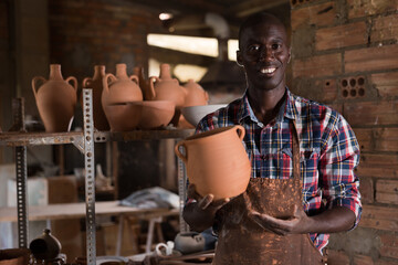 Friendly experienced salesman of pottery store offering handmade ceramic goods