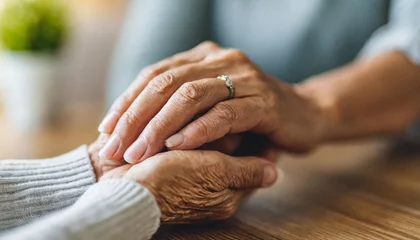 Fotobehang young woman and a senior lady, as they share a tender hand-holding moment, symbolizing intergenerational love and care © Your Hand Please