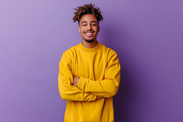 Obraz premium Portrait of a smiling african american man with afro hairstyle wearing yellow hoodie standing isolated over violet background
