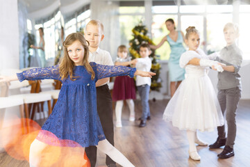 New Year performance - beautifully dressed children dance classical dances at the Christmas ball