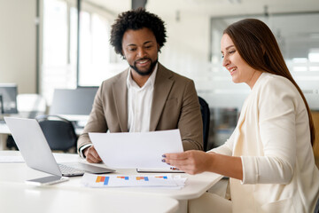 A professional meeting between a man and a woman, both dressed in business attire, discussing...