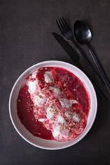 A plate of cheese fritters in cream-cherry sauce top view, flat lay on dark background