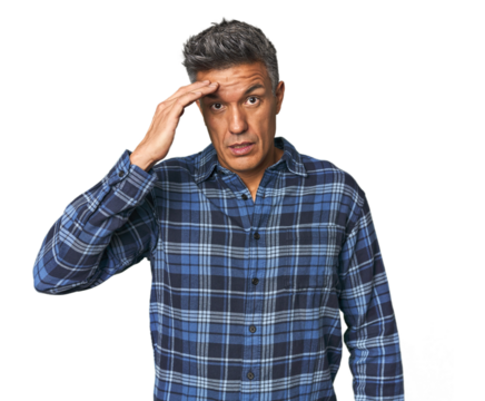 Middle-aged Latino man shouts loud, keeps eyes opened and hands tense.