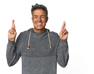 Middle-aged Latino man crossing fingers for having luck