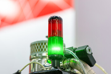 Signal traffic light of industrial equipment. The traffic light consists of two sections: the upper one is red, the lower one is green. The traffic light is green