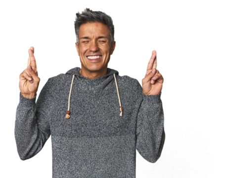 Middle-aged Latino man crossing fingers for having luck
