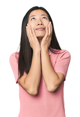 Young Chinese woman in studio setting whining and crying disconsolately.