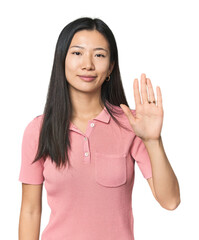 Young Chinese woman in studio setting smiling cheerful showing number five with fingers.