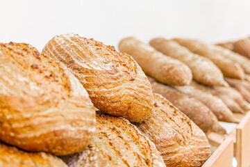 Freshly baked bread on a counter in a bakery, close-up. Bakery products. Sale of bread and loaves